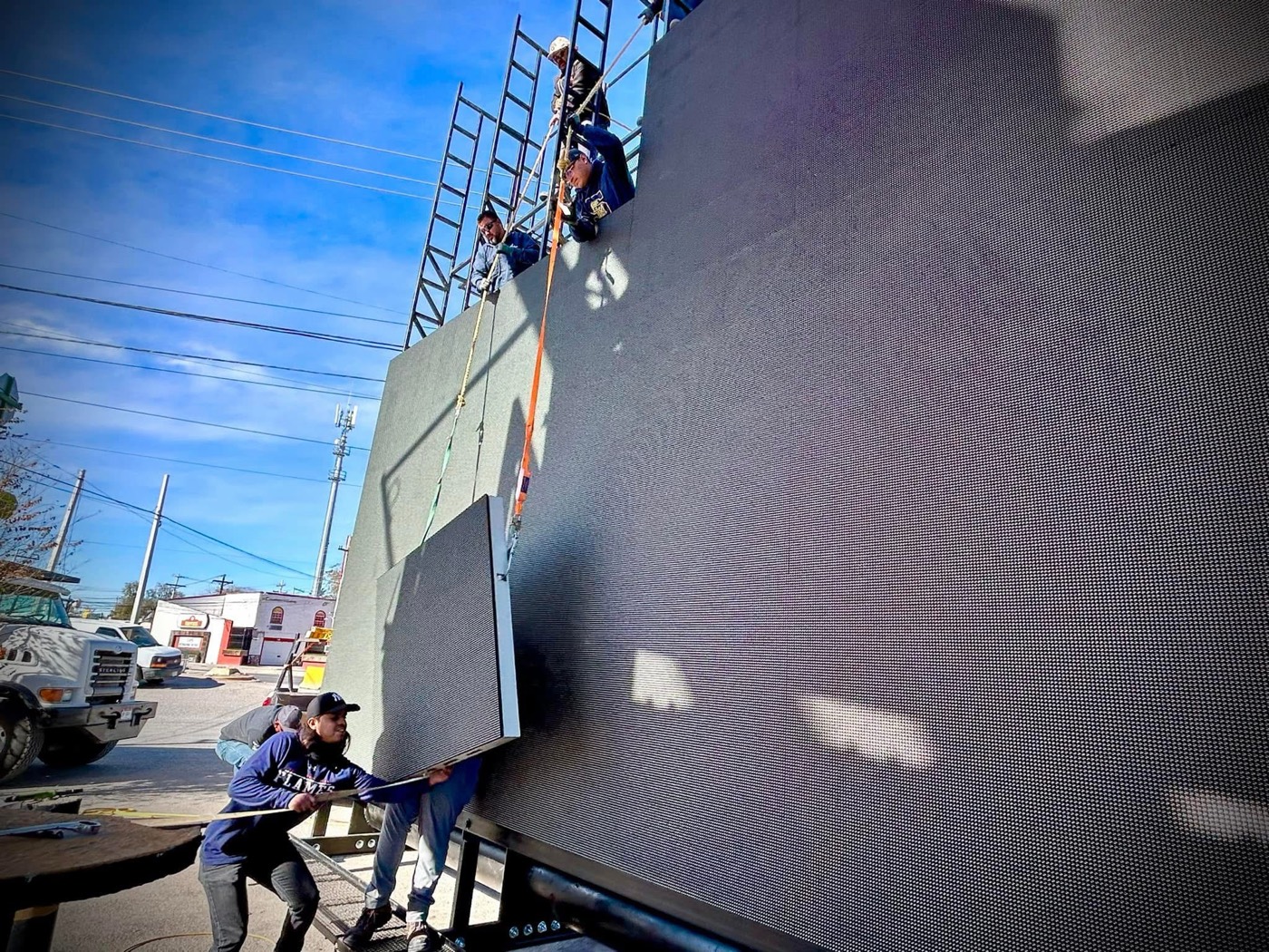 Equipo de Spotled subiendo un gabinete a la estructura